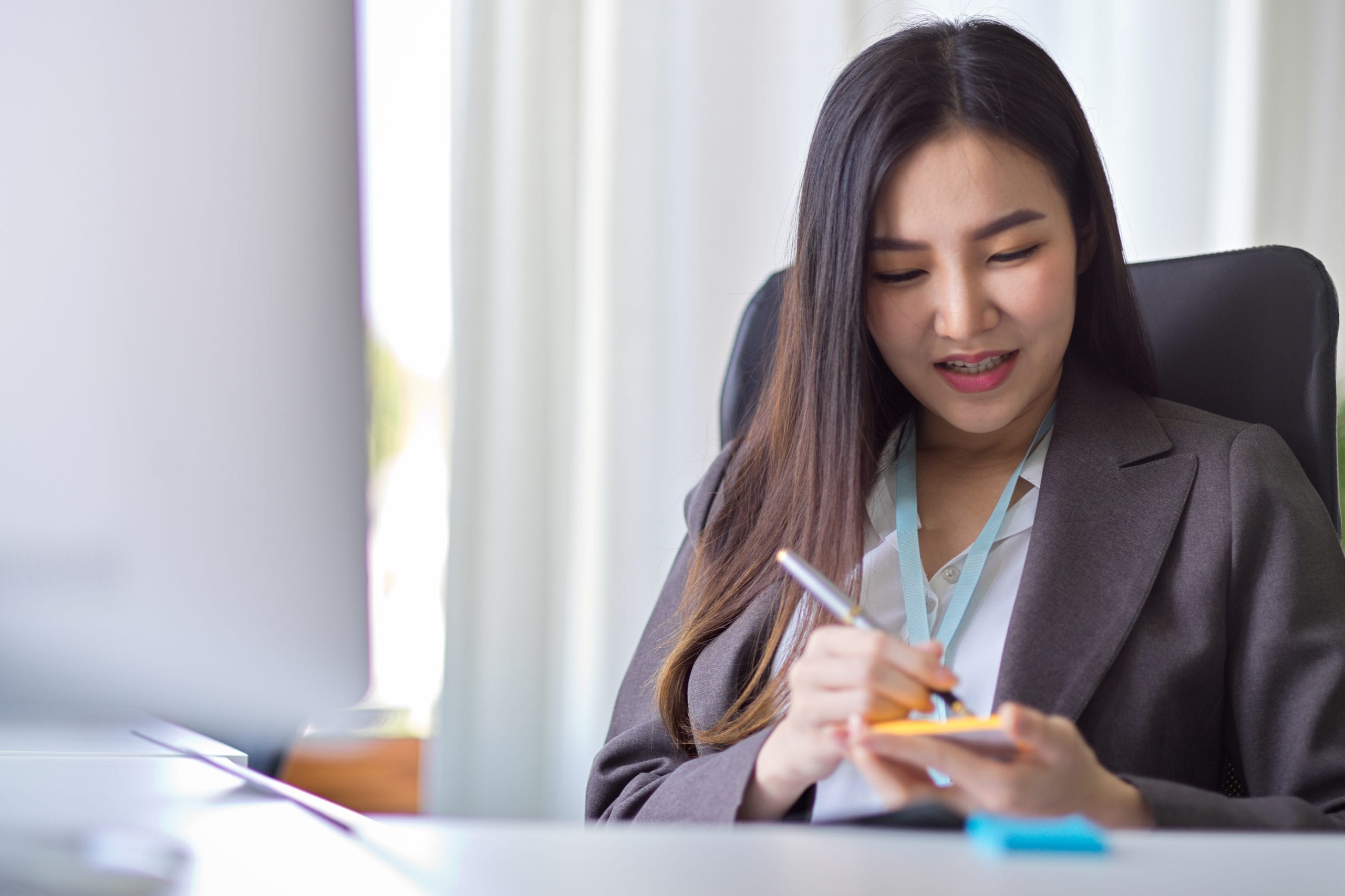 Businesswoman takes notes on a sticky note