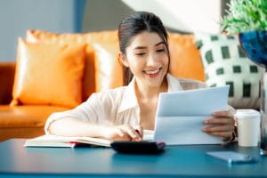 Happy woman paying bills accounting costs charges taxes and cred